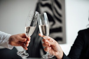 Para młoda wznosząca toast lampkami szampana podczas wesela.