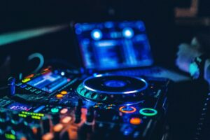 DJ obsługujący konsoletę z kolorowym oświetleniem na weselu